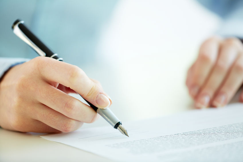 Business worker signing the contract to conclude a deal
